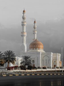 Stunning capture of a mosque in Oman with a distinctive golden dome and towering minarets.