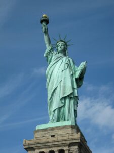 The Statue of Liberty serves as a symbol of freedom against a clear blue sky in New York City.